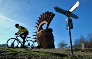 Silvanus sculpture with cyclist and sign